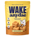 A stand-up pouch of Wake Anydae Coffee Cacao Cream Bites in Mocha Sundae flavor, shown on a plain white background. The packaging is primarily yellow on the upper half and brown on the lower half, with large navy brand text and an illustration of a white ghost sitting on a stack of tan cream bites.